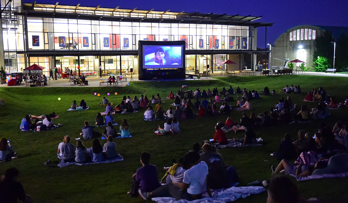 Students watching movie outside of student center